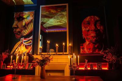 Salle sombre avec éclairage tamisé rouge, mobilier élégant, chandeliers et étagères illuminées derrière un bar.