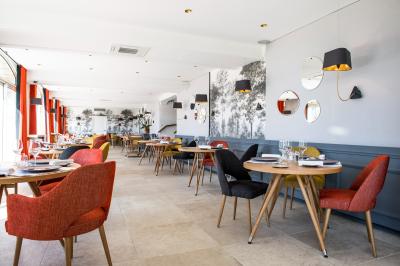 Salle de réunion lumineuse avec tables disposées en U, chaises jaunes, écran de projection et tableau blanc.