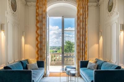 Salle de réunion lumineuse avec tables disposées en U, chaises jaunes, écran de projection et tableau blanc.