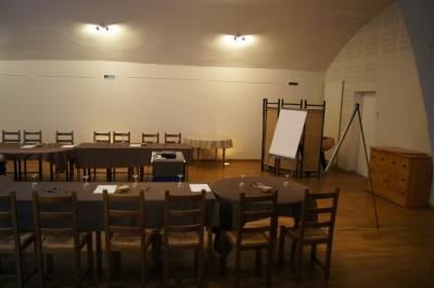 Part de gâteau au caramel décorée d'une fleur jaune, accompagnée de chantilly, servie sur une ardoise noire.