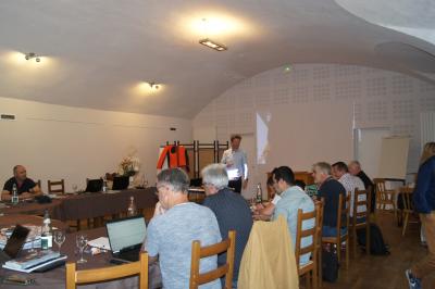 Part de gâteau au caramel décorée d'une fleur jaune, accompagnée de chantilly, servie sur une ardoise noire.