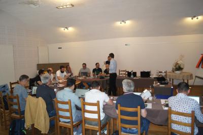 Part de gâteau au caramel décorée d'une fleur jaune, accompagnée de chantilly, servie sur une ardoise noire.