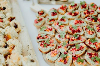 Arbuste à feuillage dense à gauche et arbre taillé à droite dans un jardin verdoyant sous un ciel clair.