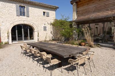 Arbuste à feuillage dense à gauche et arbre taillé à droite dans un jardin verdoyant sous un ciel clair.
