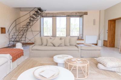 Arbuste à feuillage dense à gauche et arbre taillé à droite dans un jardin verdoyant sous un ciel clair.