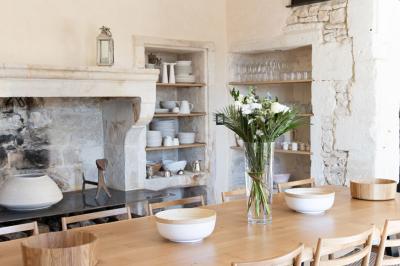 Arbuste à feuillage dense à gauche et arbre taillé à droite dans un jardin verdoyant sous un ciel clair.
