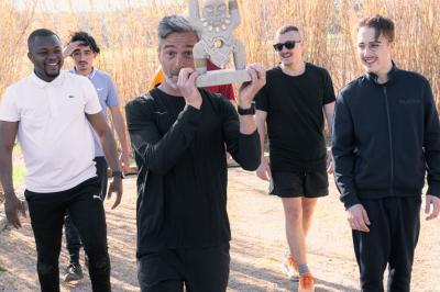 Arbuste à feuillage dense à gauche et arbre taillé à droite dans un jardin verdoyant sous un ciel clair.
