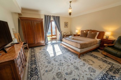 Miniature Location salle Chaumes-en-Brie (Seine-et-Marne) - Château de Crénille #53 Chambre lumineuse avec lit double, meubles en bois sculpté, tapis décoratif et grande fenêtre avec rideaux.