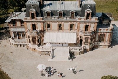 Miniature Location salle Chaumes-en-Brie (Seine-et-Marne) - Château de Crénille #31 Chambre lumineuse avec lit double, meubles en bois sculpté, tapis décoratif et grande fenêtre avec rideaux.