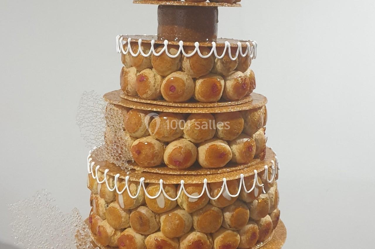 Pièce montée en choux et caramel décorée de dentelle de sucre, d'une rose blanche et d'une inscription personnalisée.