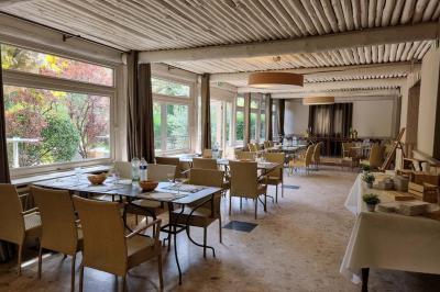 Vue aérienne d'une zone rurale avec des arbres, un cours d'eau sinueux et des bâtiments aux toits rouges.