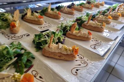 Vue aérienne d'une zone rurale avec des arbres, un cours d'eau sinueux et des bâtiments aux toits rouges.
