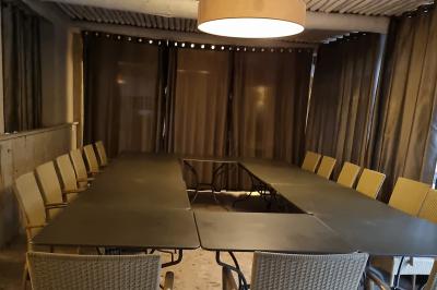 Vue aérienne d'une zone rurale avec des arbres, un cours d'eau sinueux et des bâtiments aux toits rouges.