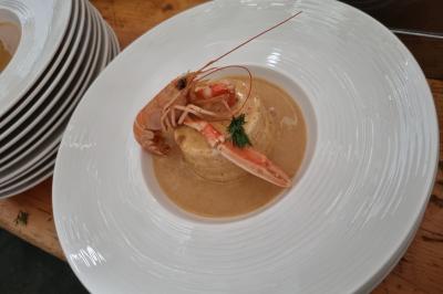 Vue aérienne d'une zone rurale avec des arbres, un cours d'eau sinueux et des bâtiments aux toits rouges.