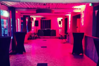 Vue aérienne d'une zone rurale avec des arbres, un cours d'eau sinueux et des bâtiments aux toits rouges.