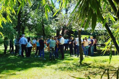 Vue aérienne d'une zone rurale avec des arbres, un cours d'eau sinueux et des bâtiments aux toits rouges.