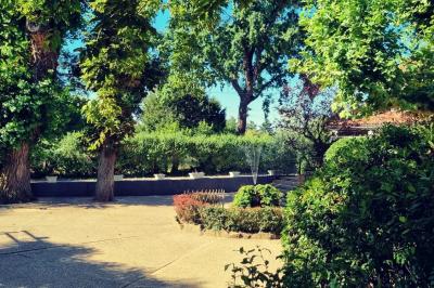 Vue aérienne d'une zone rurale avec des arbres, un cours d'eau sinueux et des bâtiments aux toits rouges.