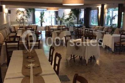 Vue aérienne d'une zone rurale avec des arbres, un cours d'eau sinueux et des bâtiments aux toits rouges.