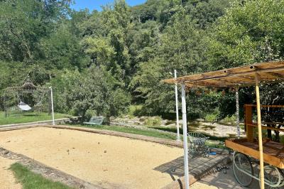 Table décorée pour un événement, avec nappes blanches, fleurs, bougies et couverts dorés dans un cadre extérieur.