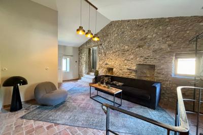 Table décorée pour un événement, avec nappes blanches, fleurs, bougies et couverts dorés dans un cadre extérieur.
