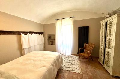 Table décorée pour un événement, avec nappes blanches, fleurs, bougies et couverts dorés dans un cadre extérieur.