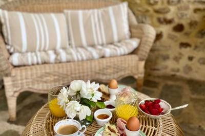 Table décorée pour un événement, avec nappes blanches, fleurs, bougies et couverts dorés dans un cadre extérieur.