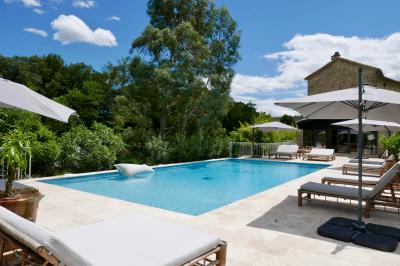 Table décorée pour un événement, avec nappes blanches, fleurs, bougies et couverts dorés dans un cadre extérieur.