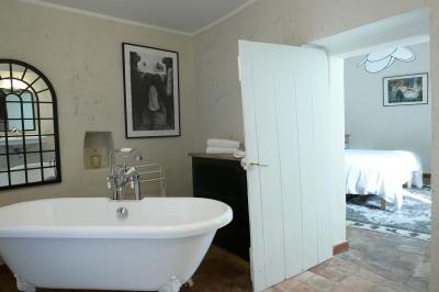 Table décorée pour un événement, avec nappes blanches, fleurs, bougies et couverts dorés dans un cadre extérieur.