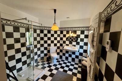 Table décorée pour un événement, avec nappes blanches, fleurs, bougies et couverts dorés dans un cadre extérieur.