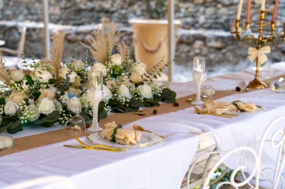 Rivière bordée de rochers et de végétation sous un ciel bleu, avec une maison partiellement visible en arrière-plan.