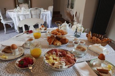 Rivière bordée de rochers et de végétation sous un ciel bleu, avec une maison partiellement visible en arrière-plan.