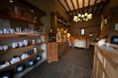Chambre chaleureuse avec lits, canapé, fauteuils en osier, table basse et éclairage tamisé, décor rustique.