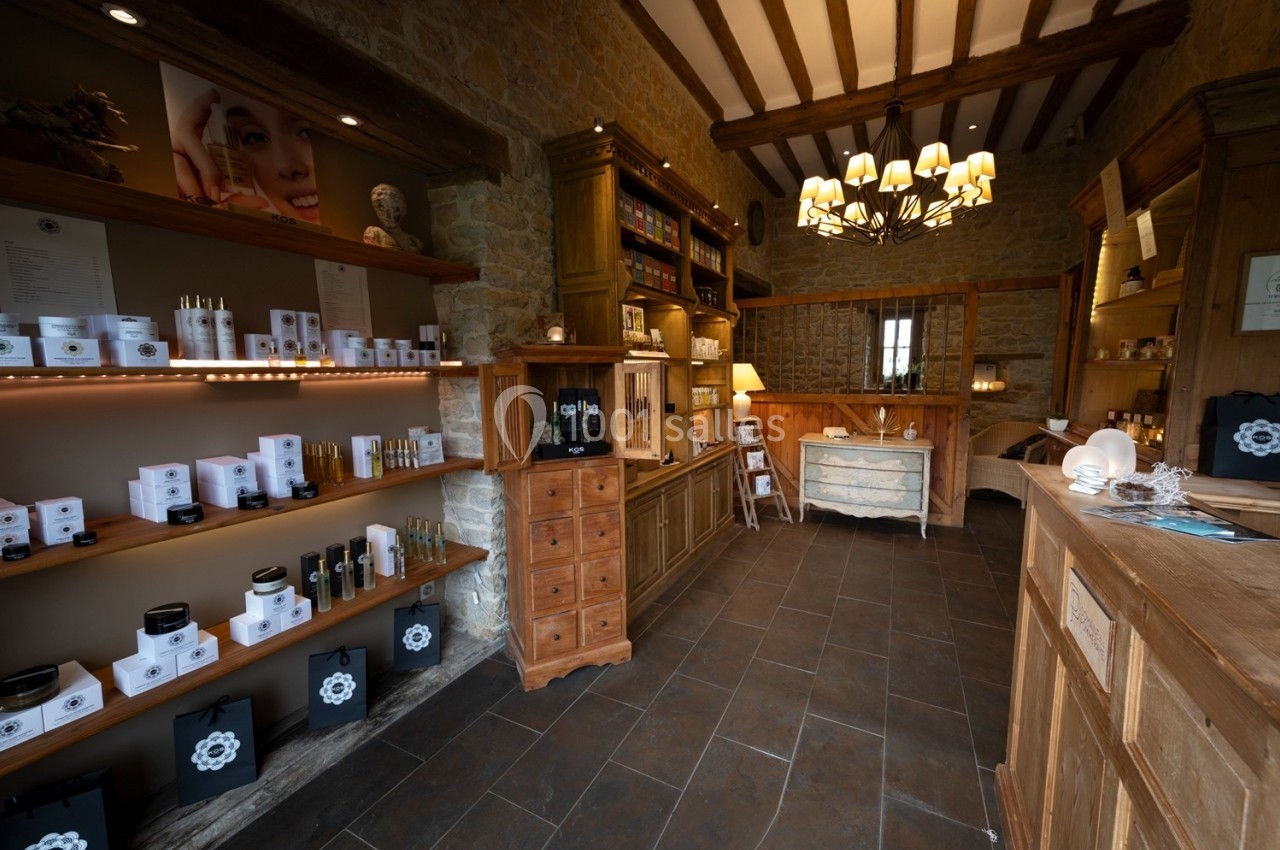 Intérieur d'une boutique avec des étagères remplies de produits de soins et un comptoir en bois dans un décor rustique.