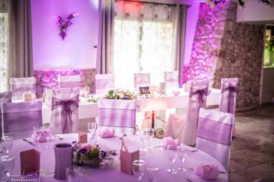 Mobilier de jardin blanc disposé sur une terrasse en gravier, avec vue sur des vignes et une forêt en arrière-plan.