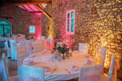 Mobilier de jardin blanc disposé sur une terrasse en gravier, avec vue sur des vignes et une forêt en arrière-plan.