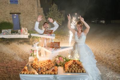 Mobilier de jardin blanc disposé sur une terrasse en gravier, avec vue sur des vignes et une forêt en arrière-plan.