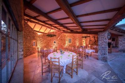 Mobilier de jardin blanc disposé sur une terrasse en gravier, avec vue sur des vignes et une forêt en arrière-plan.