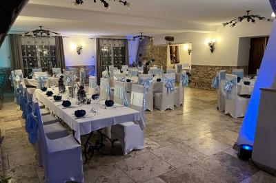 Mobilier de jardin blanc disposé sur une terrasse en gravier, avec vue sur des vignes et une forêt en arrière-plan.