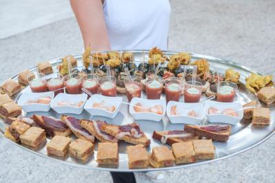 Mobilier de jardin blanc disposé sur une terrasse en gravier, avec vue sur des vignes et une forêt en arrière-plan.