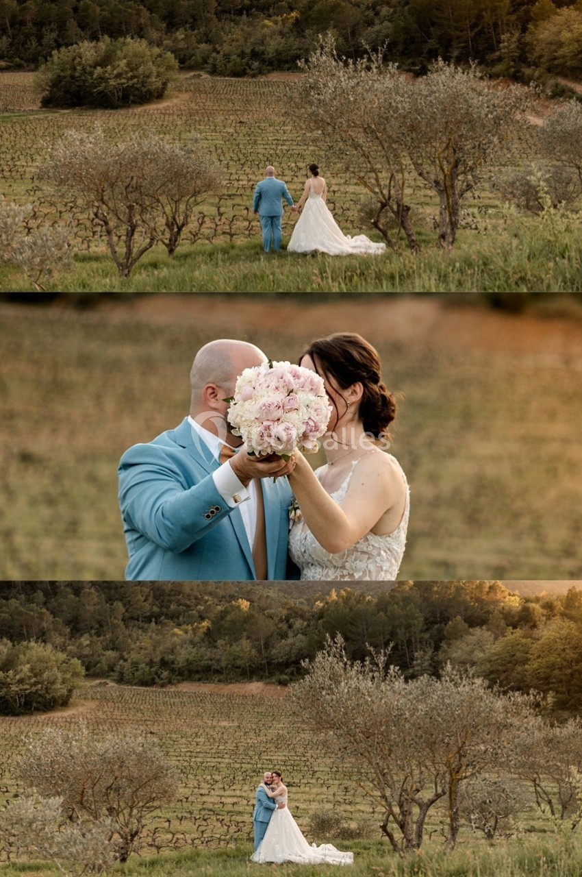 Un couple en tenue de mariage dans un paysage champêtre, entouré de vignes et d'arbres, tenant un bouquet de fleurs.