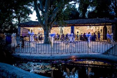Mobilier de jardin blanc disposé sur une terrasse en gravier, avec vue sur des vignes et une forêt en arrière-plan.