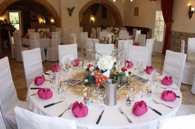 Mobilier de jardin blanc disposé sur une terrasse en gravier, avec vue sur des vignes et une forêt en arrière-plan.