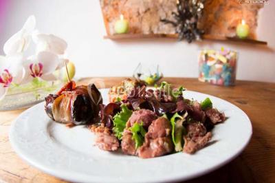 Mobilier de jardin blanc disposé sur une terrasse en gravier, avec vue sur des vignes et une forêt en arrière-plan.