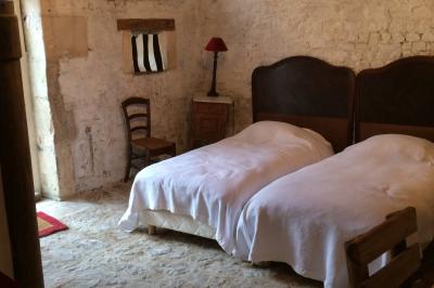 Chambre lumineuse au style ancien avec lit à baldaquin, meubles en bois sculpté et vue sur un jardin verdoyant.