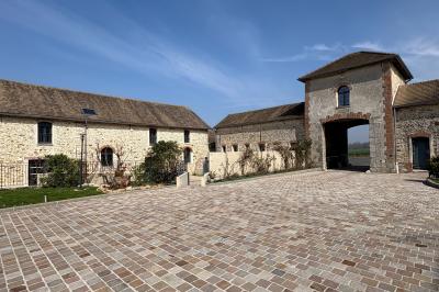 Chambre avec quatre lits superposés, draps à motifs verts, sol en carrelage gris et lumière naturelle provenant d'une…