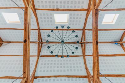 Chambre avec quatre lits superposés, draps à motifs verts, sol en carrelage gris et lumière naturelle provenant d'une…