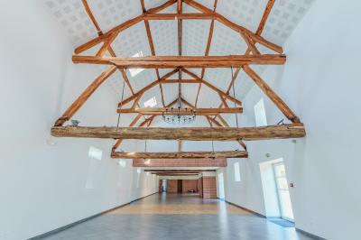 Chambre avec quatre lits superposés, draps à motifs verts, sol en carrelage gris et lumière naturelle provenant d'une…