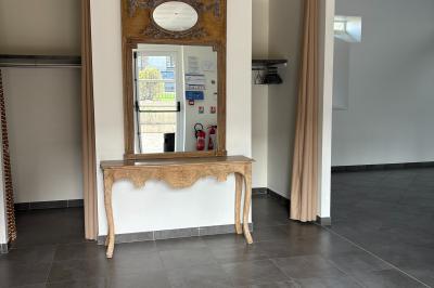 Chambre avec quatre lits superposés, draps à motifs verts, sol en carrelage gris et lumière naturelle provenant d'une…