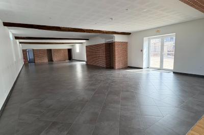 Chambre avec quatre lits superposés, draps à motifs verts, sol en carrelage gris et lumière naturelle provenant d'une…
