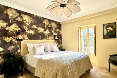 Vue aérienne d'un terrain de tennis rouge entouré de forêt, avec une petite mare et des prairies avoisinantes.